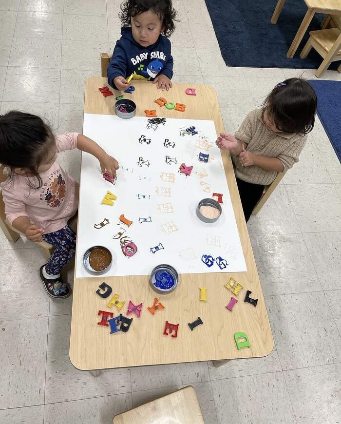 Children stamp painting letters at Sunny West