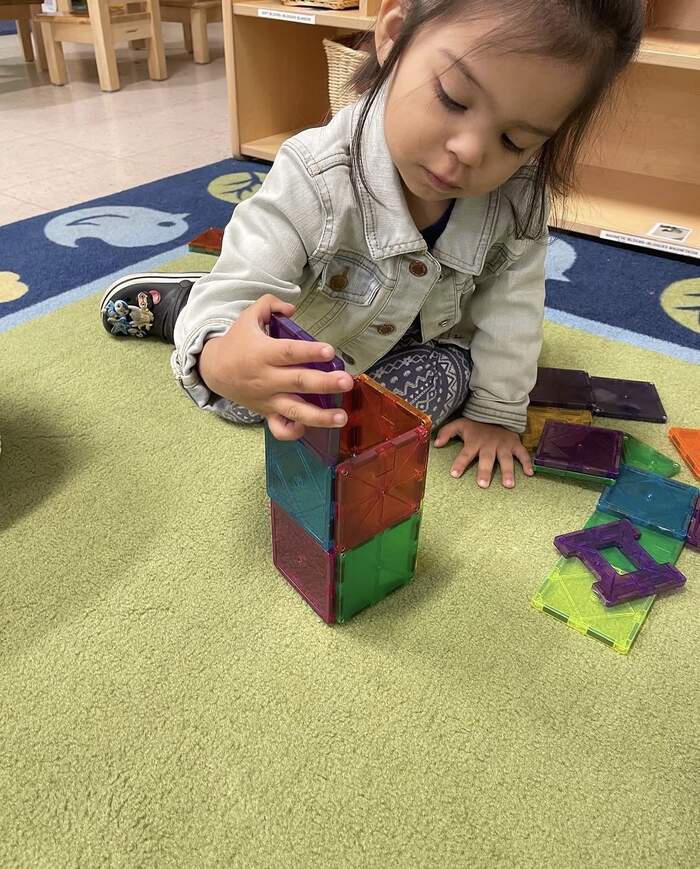 Toddler building with magnetic tiles at Sunny West