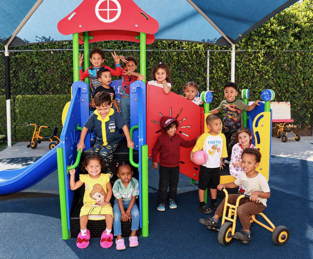 A group of smiling Sunny West children on the playground